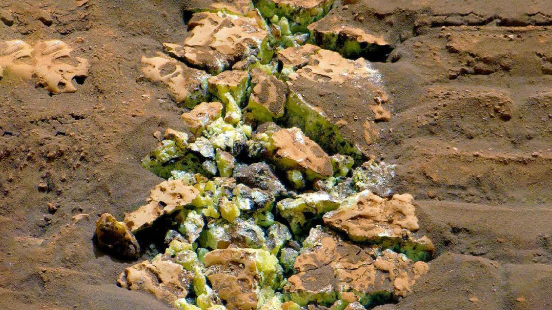 Cracked Martian rock revealing bright yellow crystals in Curiosity rover track at Gediz Vallis, Mount Sharp.