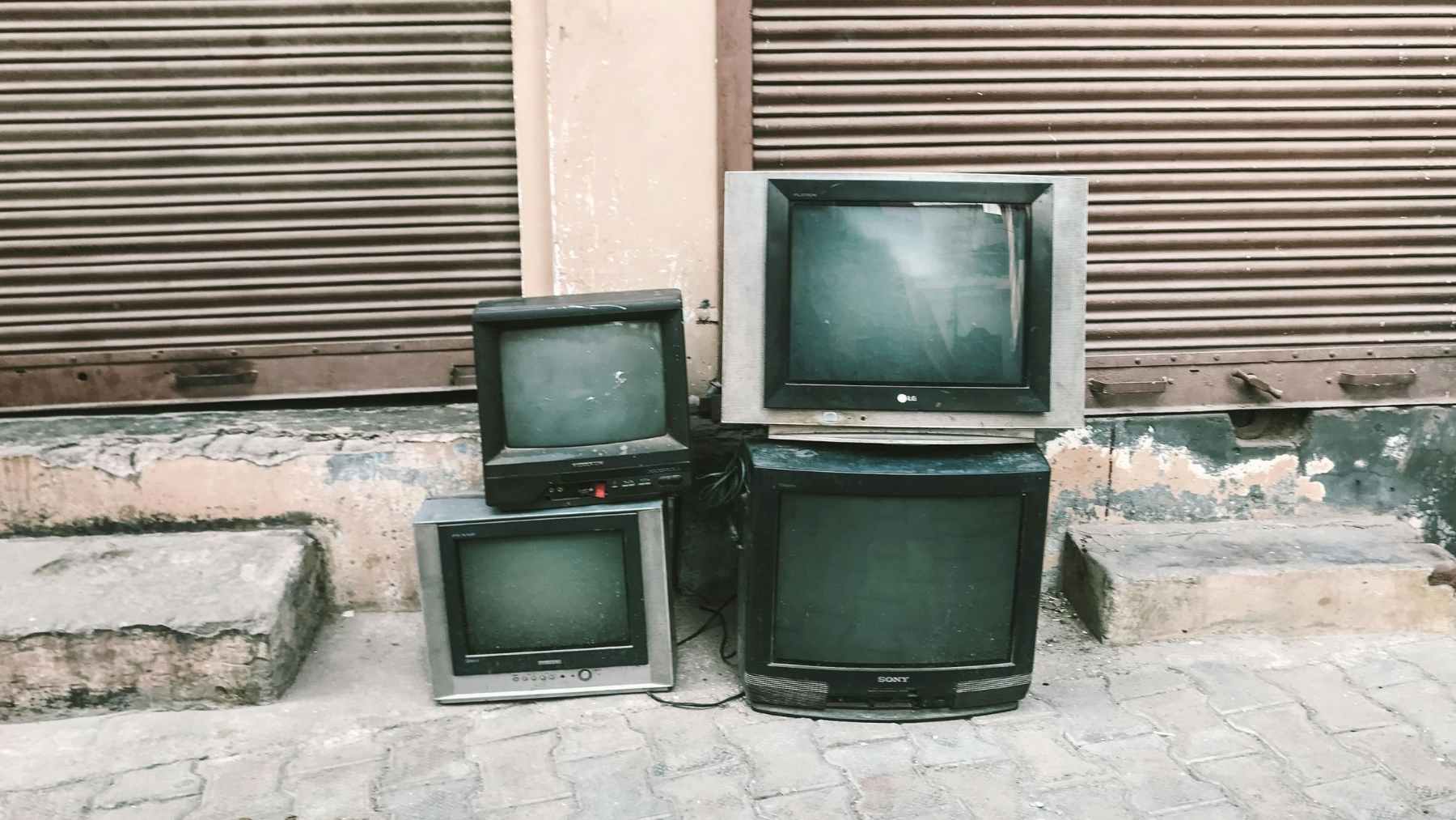 Televisores antiguos abandonados en la calle como ejemplo de residuos electrónicos