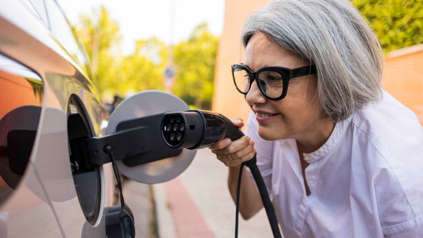 Mujer cargando un coche eléctrico en un punto de recarga doméstico en Chipre