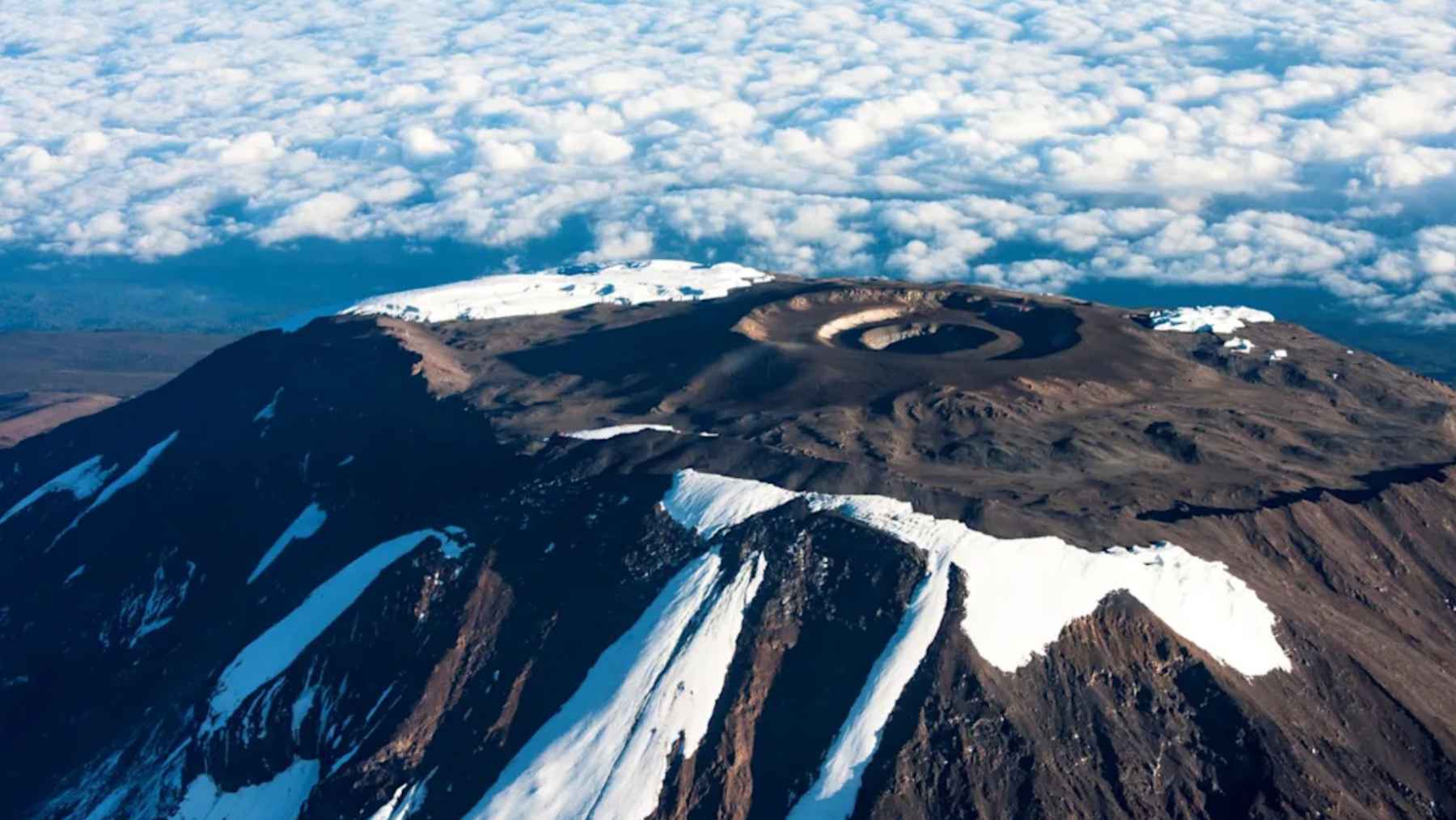 Vista aérea del monte Kilimanjaro con retroceso de nieve y pérdida de vegetación natural en sus laderas