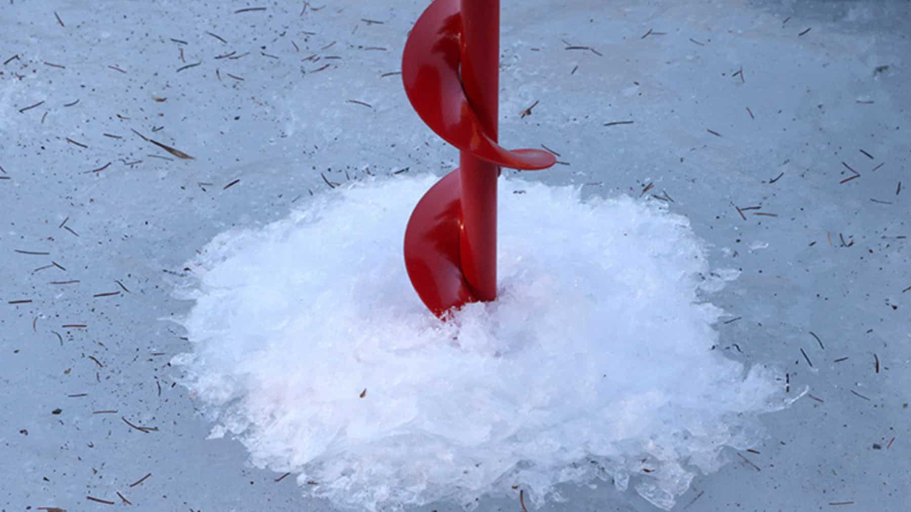 Taladro perforando una capa de hielo en un lago congelado